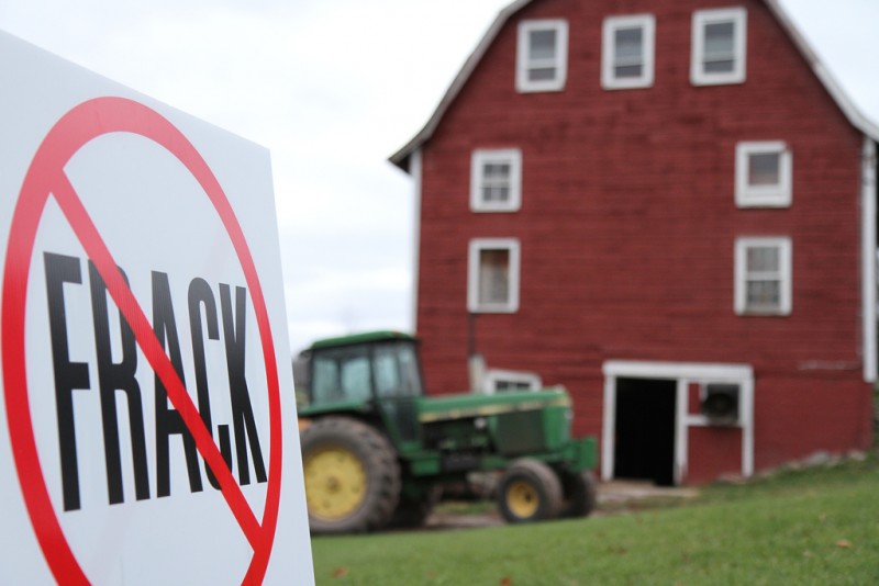 A sign that reads "NO Fracking" appears in front of an old-fashioned red farmhouse. (Flickr / Not An Alternative)