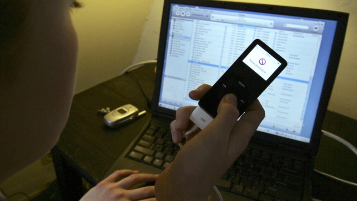 Music is downloaded from a computer to an iPod , in this May 9, 2006 file photo taken in Paris. (AP Photo/Jacques Brinon, file)