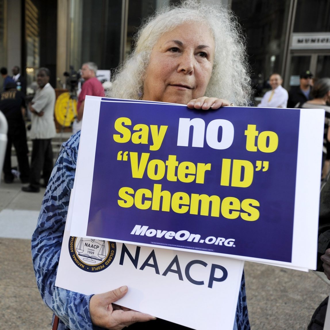 Gloria Gilman holds a sign during the NAACP voter ID rally to demonstrate the opposition of Pennsylvania's new voter identification law, Thursday, Sept. 13, 2012, in Philadelphia. (AP Photo/Michael Perez)