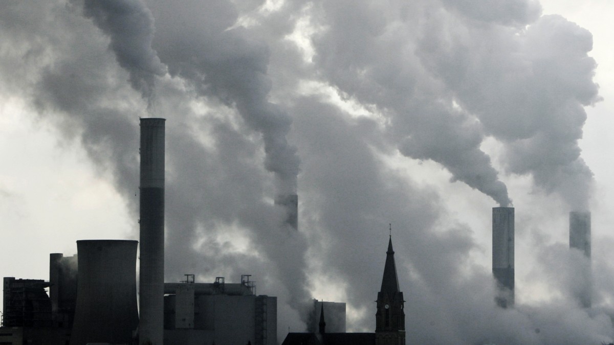 In this Feb. 25, 2008 file photo the tower of a church is seen between the smoke billowing chimneys of the brown coal power plant Frimmersdorf in Grevenbroich near Duesseldorf, Germany. (AP Photo/Frank Augstein, File)