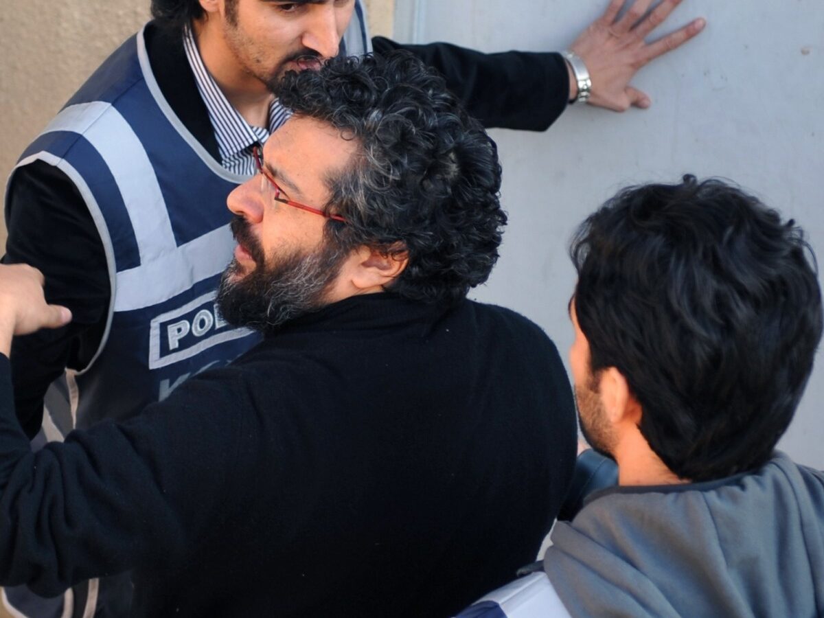 Police officers escort journalist Soner Yalcin, centre, during a medical check in Istanbul, Turkey, Thursday, Feb. 17, 2011. (AP Photo)