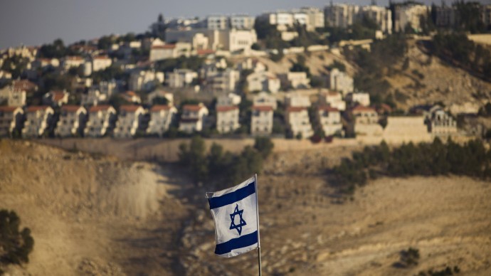 FILE - In this Monday, Sept. 7, 2009 file photo, an Israeli flag is seen in front of the West Bank Jewish settlement of Maaleh Adumim on the outskirts of Jerusalem.(AP Photo/Bernat Armangue, File)