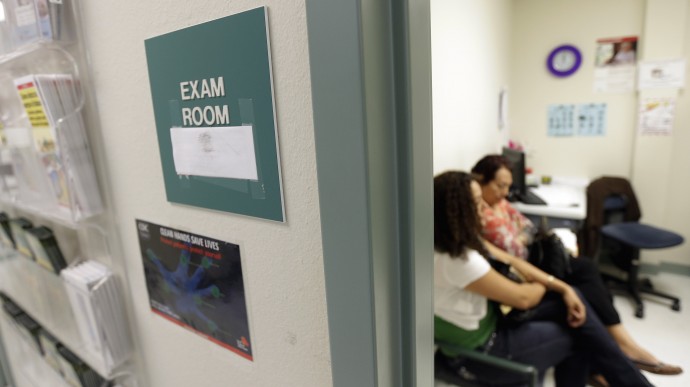 In this July 12, 2012 photo, two women wait in an exam room at Nuestra Clinica Del Valle, in San Juan, Texas. About 85 percent of those served at the clinic are uninsured. Texas already has one of the nation’s most restrictive Medicaid programs, offering coverage only to the disabled, children and parents who earn less than $2,256 a year for a family of three. Without a Medicaid expansion, the state’s working poor will continue relying on emergency rooms _ the most costly treatment option _ instead of primary care doctors. The Texas Hospital Association estimates that care for uninsured patients cost hospitals in the state $4.5 billion in 2010. (AP Photo/Eric Gay)