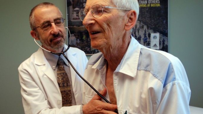 In this June 19, 2012 photo, Dr. Bruce Stowell examines patient Robert Busch at his office in Grants Pass, Ore. Stowell is among many doctors in rural areas who have capped the numbers of Medicare patients they take due to low reimbursement levels. A nationwide shortage of primary care physicians willing to set up practice in rural areas is making the problem worse. (AP Photo/Jeff Barnard)
