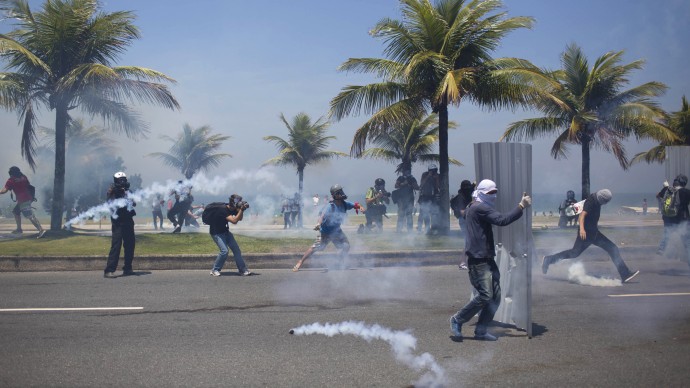 Demonstrators clash with the National Guard as they protest the auction of the Libra offshore oil field near the Windsor hotel where the auction is taking place, on the Barra da Tijuca beach in Rio de Janeiro, Brazil, Monday, Oct. 21, 2013. Monday's oil auction is the first in Brazil since the government created new production-sharing agreements. (AP Photo/Felipe Dana)