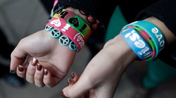 In this Feb. 20, 2013 file photo, Easton Area School District students Brianna Hawk, 15, left, and Kayla Martinez, 14, display their "I (heart) Boobies!" bracelets for photographers outside the U.S. Courthouse in Philadelphia. The Easton Area School District says it will take its fight against "I (heart) Boobies!" bracelets to the U.S. Supreme Court. The board voted 7-1 Tuesday night, Oct. 29, 2013 to appeal a decision rejecting its claim the bracelets are lewd and should be banned from school. The bracelets are designed to promote breast cancer awareness among young people. (AP Photo/Matt Rourke)