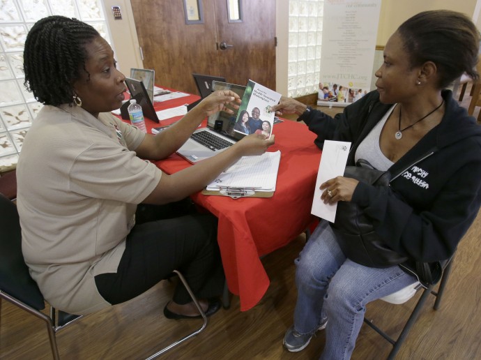 Suze Diogene, left, a certified application counselor, gives Audrey Allen information about health care, Tuesday, Oct. 1, 2013 at the Jessie Trice Community Health Center in Miami. Due to sporadic glitches in the system, counselors were mostly only able to give out information about the program and tell applicants to come back later when the system was operating. After months of build-up, The federal government is facing two major hurdles: fighting the confusion and misinformation surrounding the plan referred to as "Obamacare" and making sure the new technology systems function properly. Consumers logging onto healthcare.gov received an apology message for delays due to high traffic. The wait times at the call center and for an online chat operator were also longer than expected. (AP Photo/Wilfredo Lee)