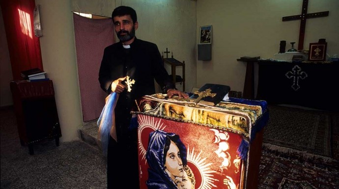 Father Andrawus stands next to the alter of the Assyrian Church in Qamishli in 1995. (photo Norbert Schiller)