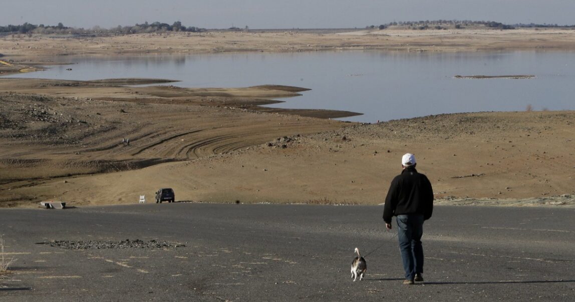 A man in Folsom Lake, Calif., walks his dog down a boat ramp that is now several hundred yards away from the waters' edge. Despite being in it's fifth year of drought, California is still allowing Nestle to pump water from state's scant supply.