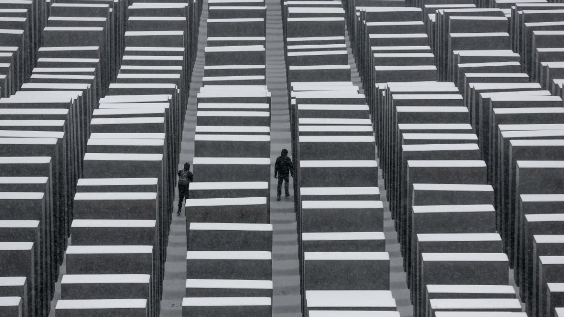 Two visitors walk inside the snow covered Holocaust Memorial at the International Holocaust Remembrance Day in Berlin, Monday, Jan. 27, 2014. The German parliament Bundestag will hold a special remembrance session at the Reichstag building in commemoration of the liberation of the Auschwitz death camp on Jan. 27, 1045. (AP Photo/Markus Schreiber)