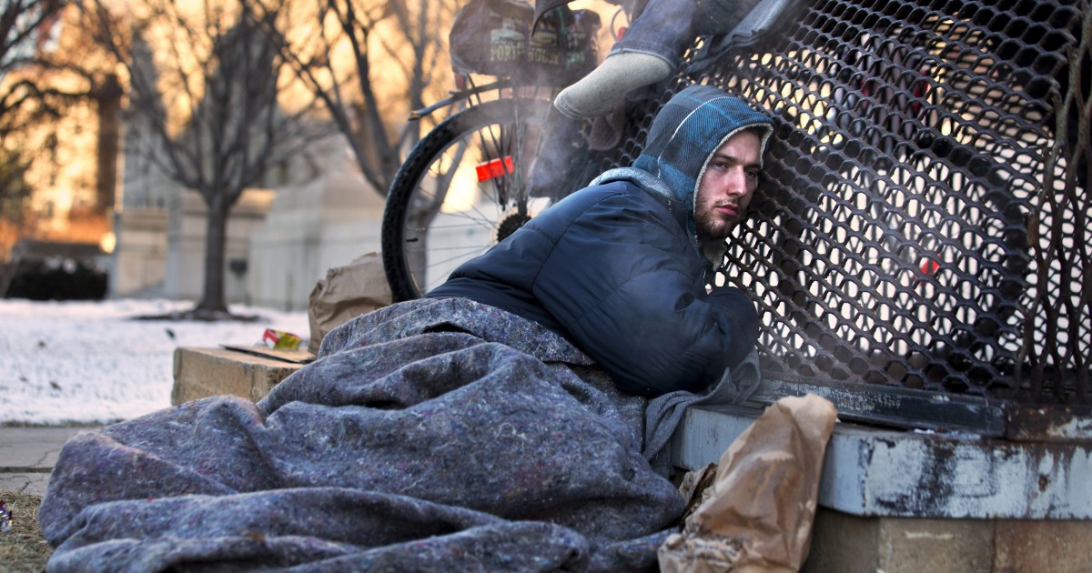 Nick warms himself on a steam grate with three other homeless men by the Federal Trade Commission, just blocks from the Capitol, during frigid temperatures in Washington, Saturday, Jan. 4, 2014. (AP Photo/Jacquelyn Martin)