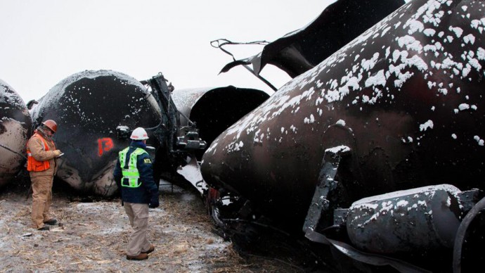 In an undated image provided by the National Transportation Safety Board NTSB board membger Robert Sumwalt, right, views damaged rail cars in Casselton, N.D.   A BNSF Railway train derailed Monday afternoon, Dec. 30, 2013,  near the eastern North Dakota town of Casselton.  (AP Photo/NTSB)