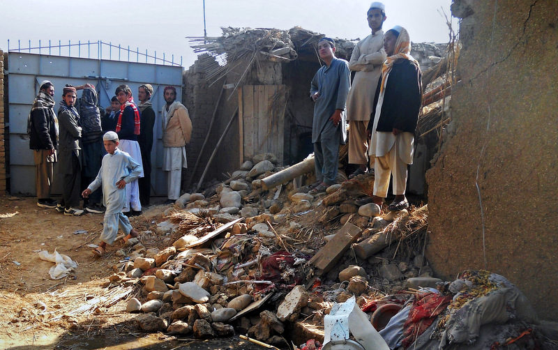 Students stand in the rubble of an Islamic seminary that was hit by a suspected U.S. drone strike