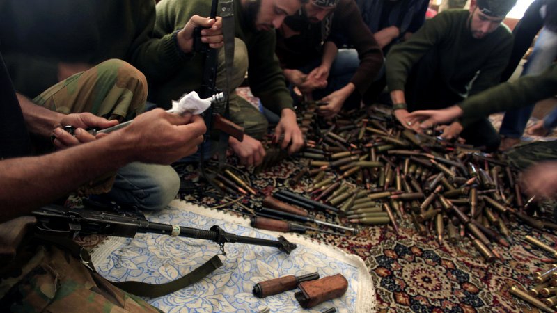 Free Syrian Army fighters clean their weapons and check ammunition at their base on the outskirts of Aleppo, Syria Nov. 14, 2012. (AP/Khalil Hamra)