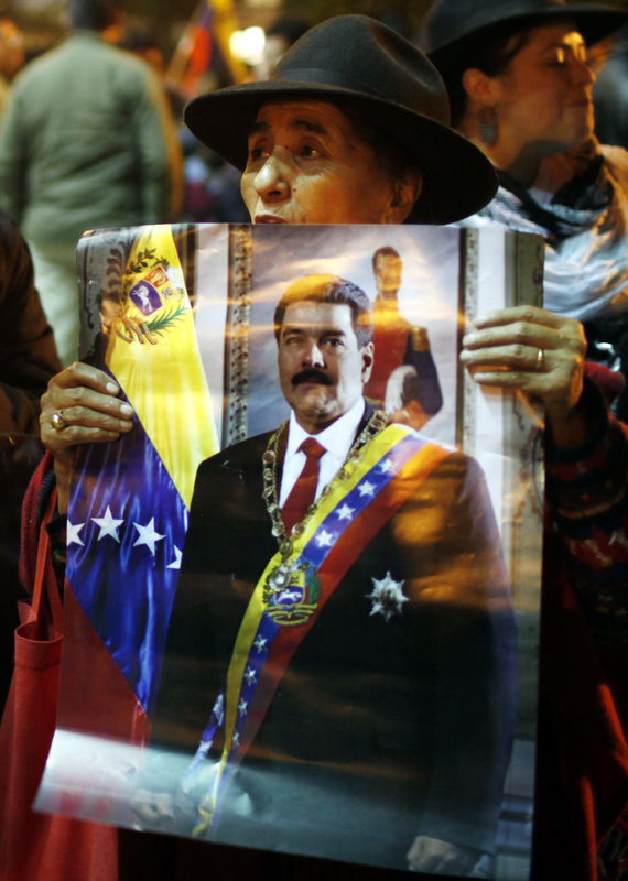 A woman holds a poster of Venezuela's President Nicolas Maduro to show support outside Venezuela's embassy in La Paz, Bolivia, Tuesday, Feb. 18, 2014. Hundreds of students have spent the past week in the streets of Caracas, Venezuela alternating between peaceful anti-government protests by day and pitched battles with police at night, in unrest fed by hardships that include rampant crime, more than 50 percent inflation and shortages of basic goods.   (AP Photo/Juan Karita)