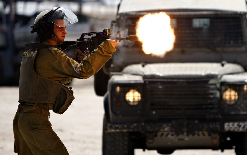 An Israeli Soldier shoots rubber bullets towards Palestinian protesters, not pictured, during a demonstration supporting prisoners in Israeli jails outside the Ofer military prison, near the West Bank city of Ramallah, Tuesday, Aug. 28, 2012. (AP Photo/Majdi Mohammed)