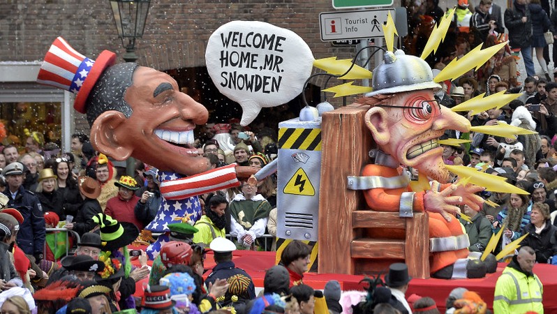 A carnival float depicting US president Barack Obama, left,  putting whistleblower Edward Snowden on an electric chair 