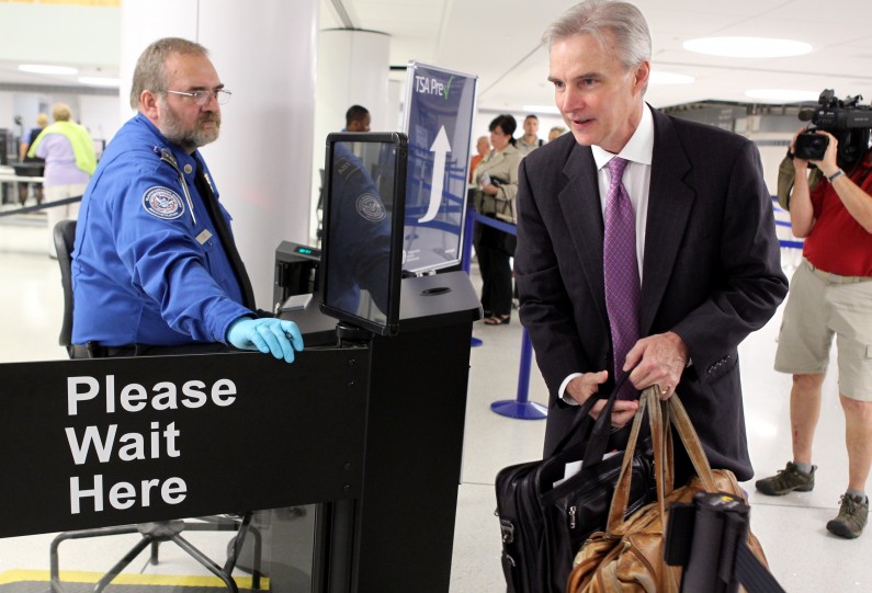 FILE - In this July 31, 2012 file photo, Transportation Security Administration agent Kevin Effan, left, allows a screened passenger to board his American Airlines flight via the new TSA PreCheck lane at Concourse C security checkpoint at Lambert-St. Louis International Airport on its first day of operation.  The TSA is expanding its PreCheck expedited screening program to passengers on international airlines. Air Canada on Tuesday, April 29, 2014 became the first international carrier to participate, with TSA officials saying other international airlines would soon sign on.  (AP Photo/St. Louis Post-Dispatch, Christian Gooden, File) EDWARDSVILLE INTELLIGENCER OUT; THE ALTON TELEGRAPH OUT