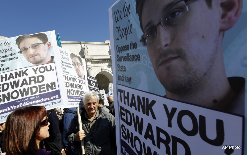 Demonstrators holds up banners with the photo of Edward Snowden during a protest outside of the U.S. Capitol in Washington