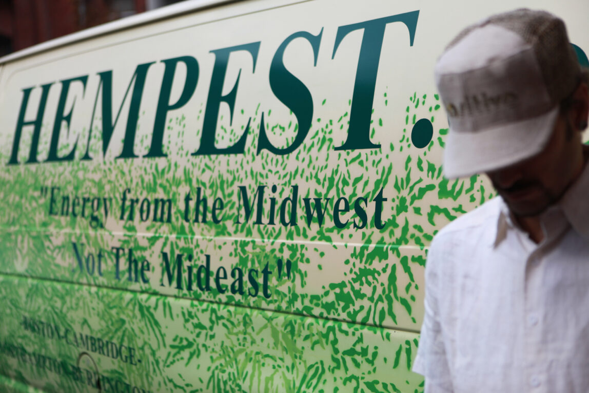 The Hempest's proprierter, wearing a baseball cap, leans against the logo van, with the slogan Energy From The Midwest Not The Mideast.