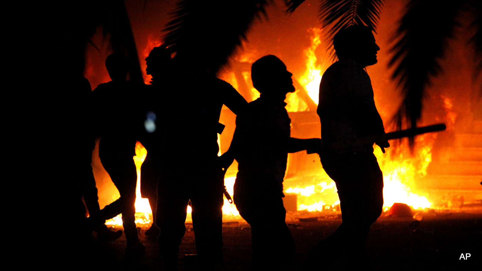 Libyan civilians watch fires at an Ansar al-Shariah Brigades compound, after hundreds of Libyans, Libyan Military, and Police raided the Brigades base, in Benghazi, Libya.