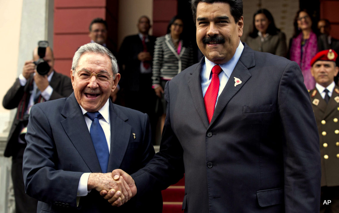 Cuba's President Raul Castro, left, shakes hands with Venezuela's President Nicolas Maduro in front of the press after arriving to Miraflores presidential palace for an emergency ALBA meeting in Caracas, Venezuela, Tuesday, March 17, 2015.