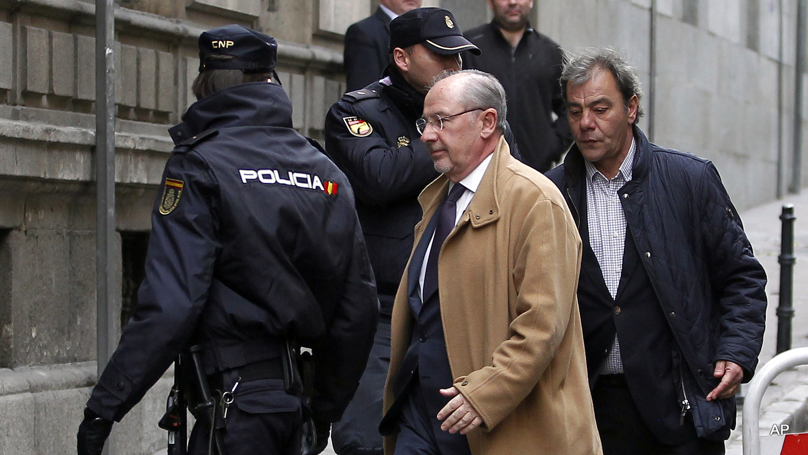 Former IMF managing director Rodrigo Rato, center, arrives at the National Court in Madrid, Spain, to answer questions over his stewardship of Spanish bank, Bankia.  Former International Monetary Fund chief Rodrigo Rato was detained by police Thursday night April 16, 2015,  according to media reports, after tax officials spent hours searching his apartment.