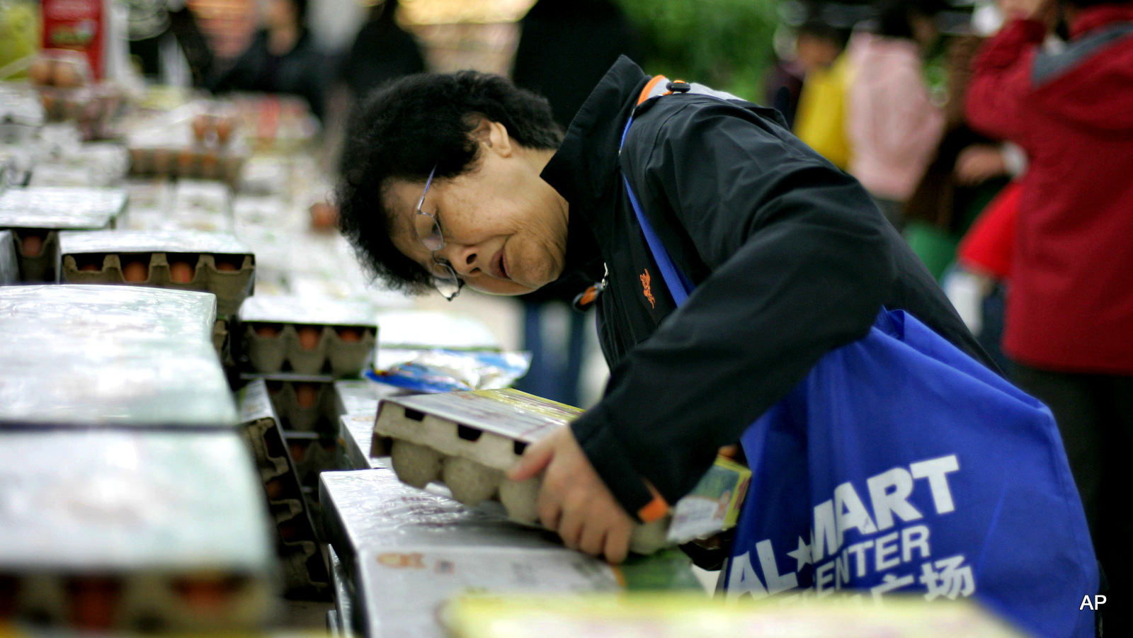 A Chinese customer inspects a carton of eggs at a WalMart branch in Beijing