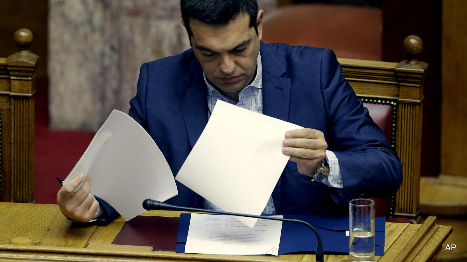 Greek Prime Minister Alexis Tsipras reads his notes as he prepares to answer opposition questions in parliament in Athens, on Friday, July 31, 2015.