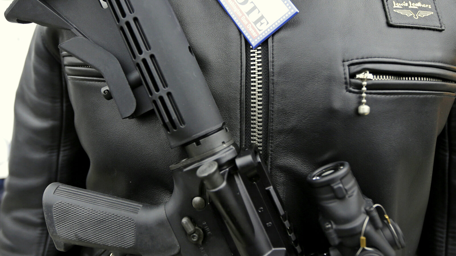 A Colt M4 gun and a button that reads "I Vote - Proud Washington Gun Owner."