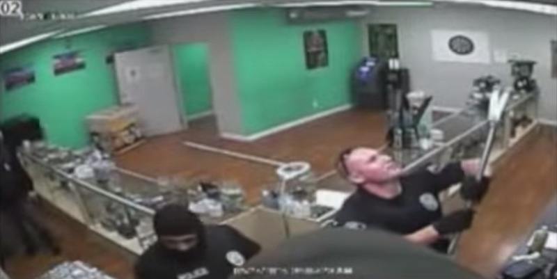 Cops remove secuirty cameras following their raid on a Santa Ana pot shop.