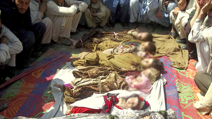 Afghan villagers sit near the bodies of children who they said were killed during a NATO air strike in the Kunar province of Afghanistan. April 7, 2013. (Reuters)