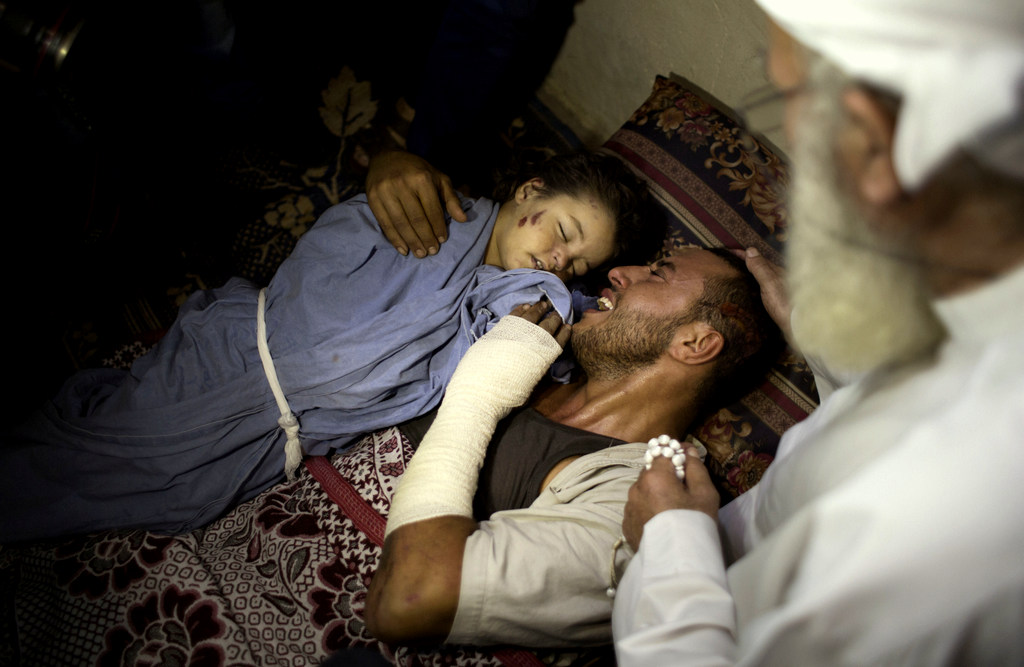 The father of two-year-old, Rahaf Hassan, weeps as he holds her body after she and her 30-year-old mother pregnant mother, Noor Hassan, were killed in Israeli air strike Sunday morning, during their funeral in the family house in the Gaza Strip, Sunday, Oct. 11, 2015. In response to renewed rocket fire toward Israel, the military said it carried out airstrikes in Gaza targeting Hamas weapons manufacturing facilities. Ashraf Al-Kidra, a Health Ministry spokesman in Gaza, said a nearby home was struck, which killed Rahaf and Noor Hassan and wounded four others including Hassan's husband and son. (AP Photo/ Khalil Hamra)