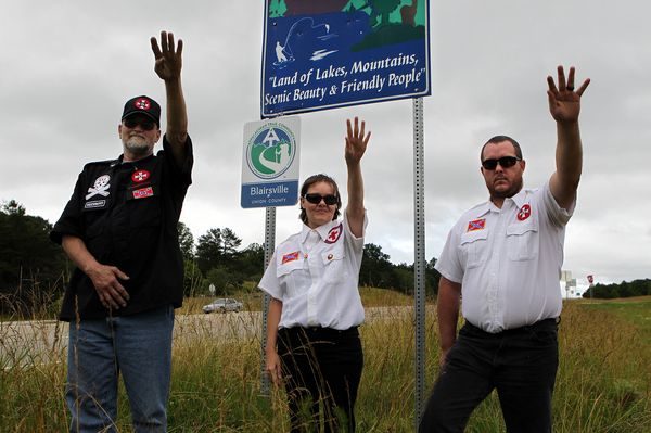 Three members of a Georgia KKK chapter salute along the portion of highway they want to adopt near Blairsville in June 2012. AJC Photo/Curtis Compton.