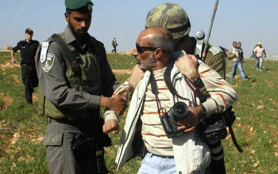 Israeli troops arrest Associated Press photographer Nasser Shiyoukhi during a Palestinian protest in Yatta in the West Bank. Shiyoukhi was later released without charge. (AP Photo)