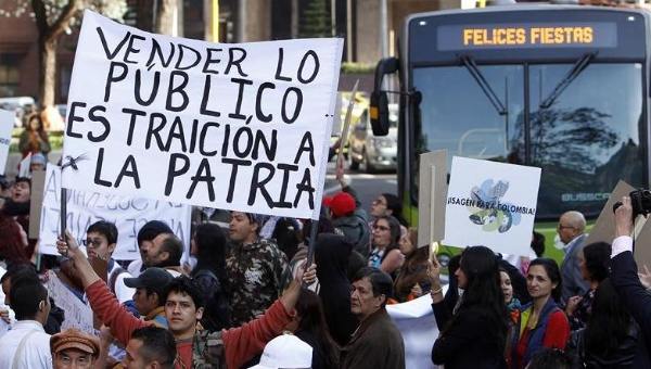 A demonstrator protesting the sale of Isagen holds up a sign that reads “Selling pubic assets is treason against the homeland,” Bogota, Colombia, Jan. 13, 2016. | Photo: EFE