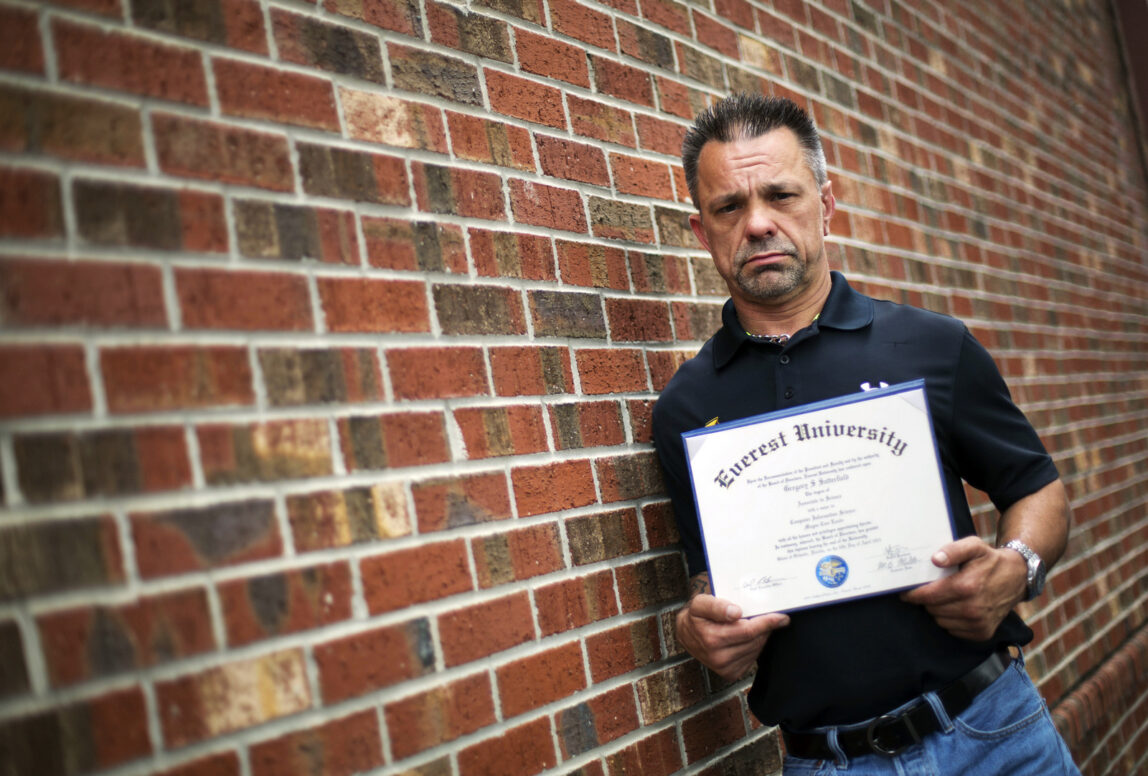 In this March 11, 2016 photo, Shane Satterfield, a roofer who owes more than $30,000 in debt for an associate’s degree in computer science from one of the country’s largest for-profit college companies that failed in 2014, holds his diploma in Atlanta. "I graduated in April at the top of my class, with honors," says Satterfield. "And I can’t get a job paying over $8.50 an hour." Despite pledging to distance itself from the poor business practices of the for-profit Corinthian Colleges Inc, the new owner of the Everest career college chain has retained key members of its staff and some of its hard-charging sales tactics. (AP Photo/David Goldman)