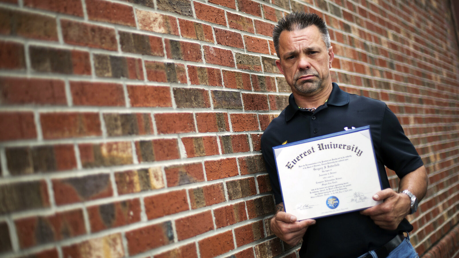 In this March 11, 2016 photo, Shane Satterfield, a roofer who owes more than $30,000 in debt for an associate’s degree in computer science from one of the country’s largest for-profit college companies that failed in 2014, holds his diploma in Atlanta. "I graduated in April at the top of my class, with honors," says Satterfield. "And I can’t get a job paying over $8.50 an hour." Despite pledging to distance itself from the poor business practices of the for-profit Corinthian Colleges Inc, the new owner of the Everest career college chain has retained key members of its staff and some of its hard-charging sales tactics. (AP Photo/David Goldman)