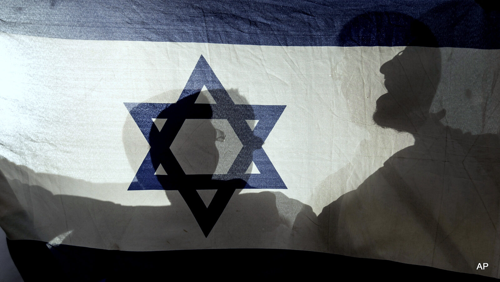 Israeli youths wave national flags as they enter Jerusalem's Old City through the Damascus Gate during a march celebrating Jerusalem Day, Sunday, June 5, 2016. Thousands of Israelis marched through Jerusalem's Old City amid high tensions on Sunday to commemorate the capture of the city's eastern sector in the 1967 Mideast war. The annual event sees flag-waving Israelis march through the city's ancient core, including Muslim areas. (AP Photo/Tsafrir Abayov)