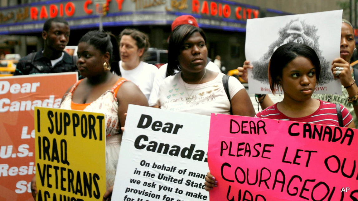 Activists stand in front of the building housing the Canadian consulate in New York on 9 July 2008 to protest the extradition of American army deserters seeking refuge in Canada.