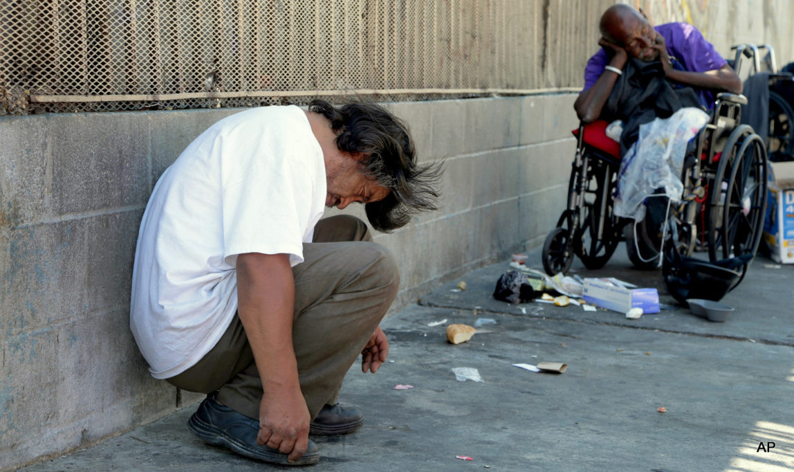 Homeless people rest in the Skid Row section of Los Angeles, Friday, Aug. 19, 2016.
