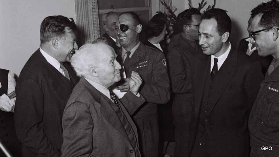 总理大卫本古里安和他的首席助手西蒙佩雷斯。背景：国防部长摩西·达扬和本·古里安的助手泰迪·科莱克。