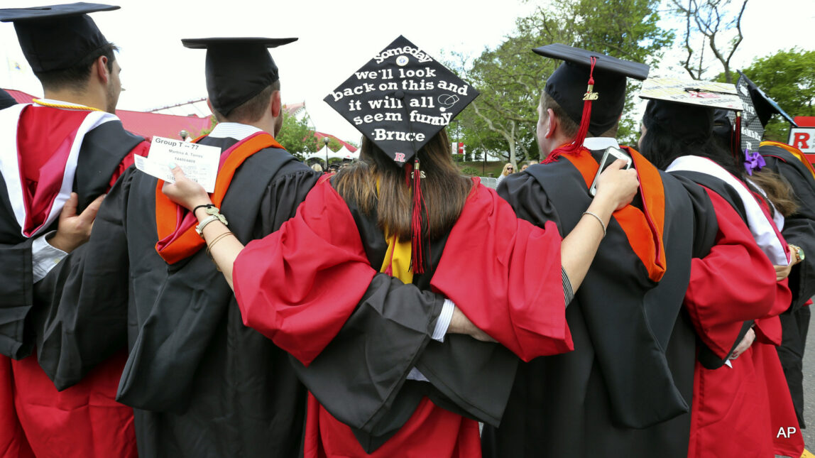 Students embrace as they arrive for the Rutgers graduation ceremonies in Piscataway, N.J.