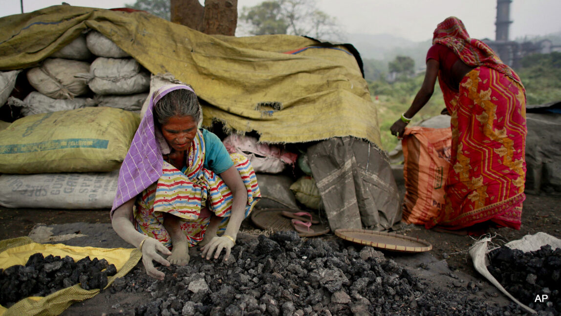 Indian women use bare hands to pick reusable pieces from heaps of used coal discarded by a carbon factory in Gauhati, India, Monday, Dec. 14, 2015.