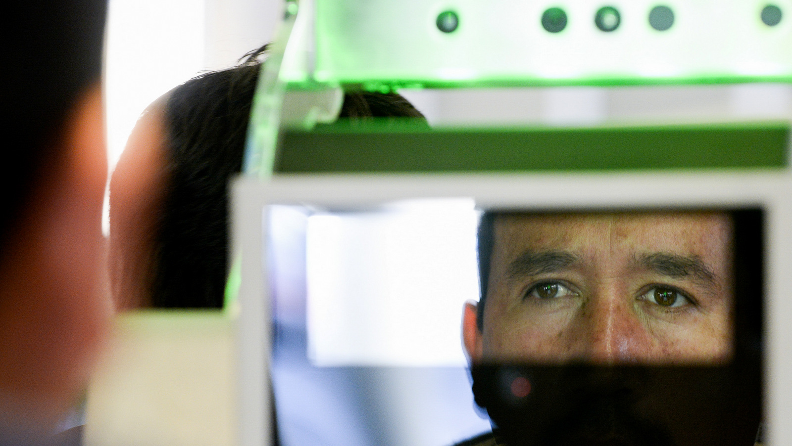 A pedestrian crossing from Mexico into the United States has his facial features and eyes scanned at a biometric kiosk Thursday, Dec. 10, 2015, in San Diego. (AP Photo/Denis Poroy)