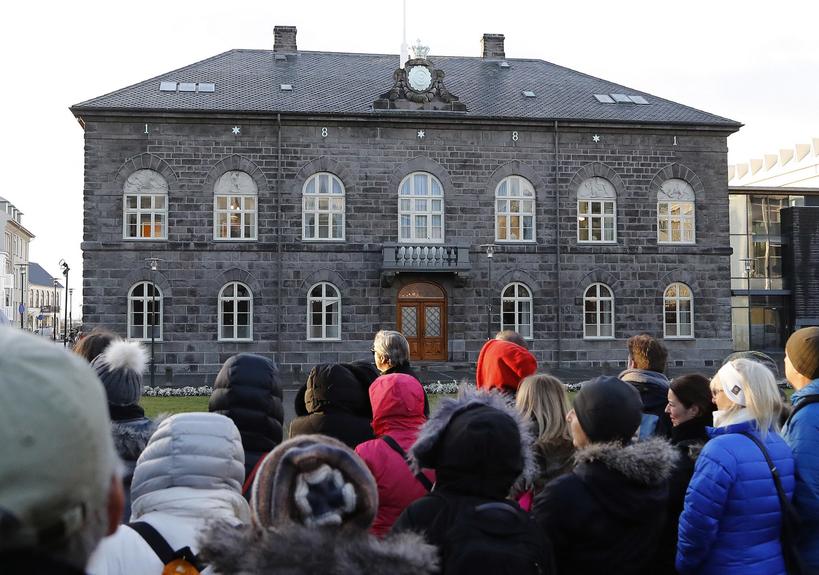 People looking at the Icelandic parliament the Althing in Reykjavik. Iceland will be the first country in the world to make employers prove they offer equal pay regardless of gender, ethnicity, sexuality or nationality, the Nordic nation's government said on International Women's Day. (AP/Frank Augstein)