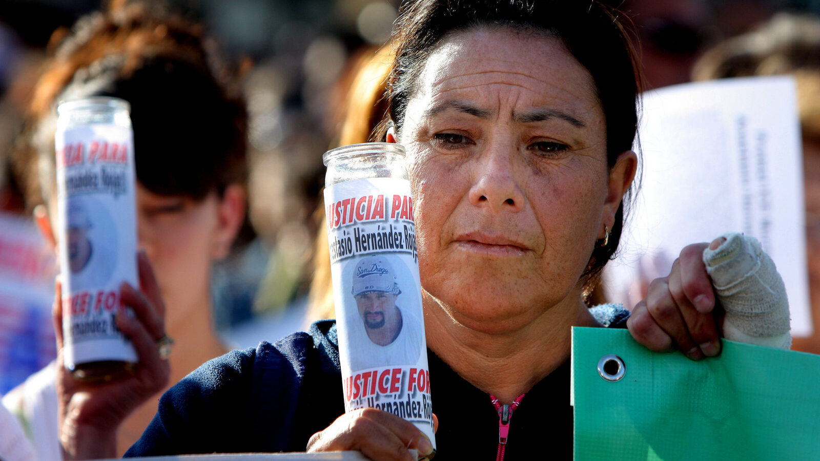 A woman holds a candle covered by a picture of late Mexican Anastasio Hernandez during a protest at the San Ysidro border crossing in Tijuana, Mexico, June 3, 2010. (AP Photo)