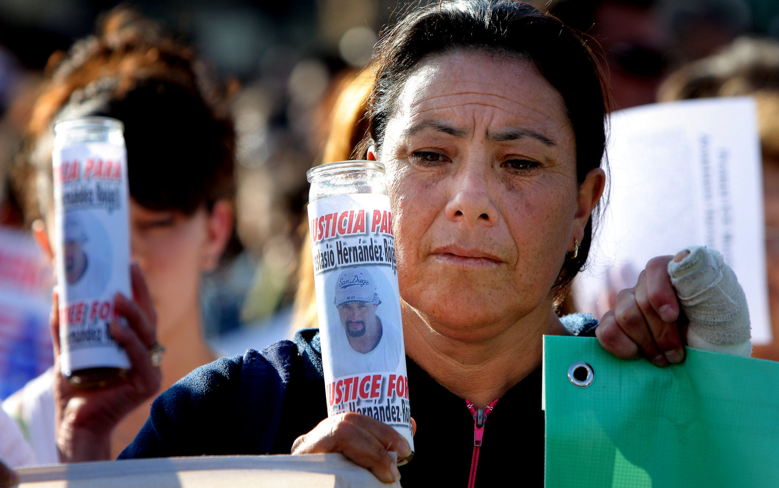 A woman holds a candle covered by a picture of late Mexican Anastasio Hernandez during a protest at the San Ysidro border crossing in Tijuana, Mexico, June 3, 2010. (AP Photo)