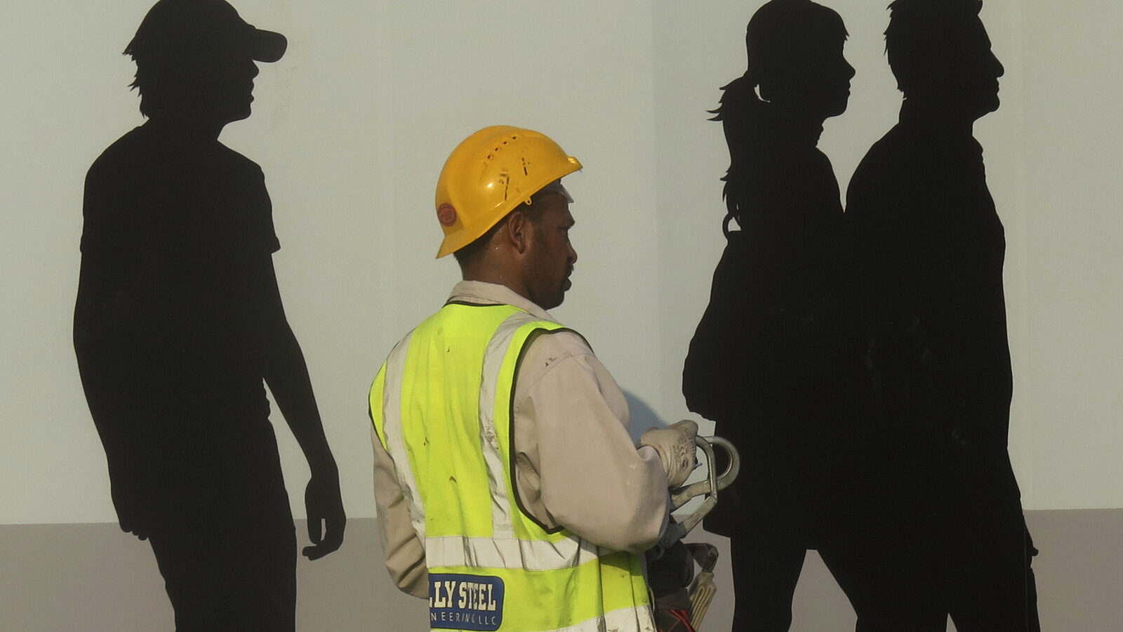 A worker passes by a wall painting in Dubai, United Arab Emirates. (AP/Kamran Jebreili)