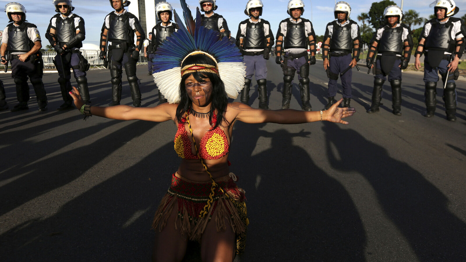A Pataxo indigenous woman performs in front of police during the Indigenous Peoples Ritual March outside the National Congress in Brasilia, Brazil, April 27, 2017. (AP/Eraldo Peres)